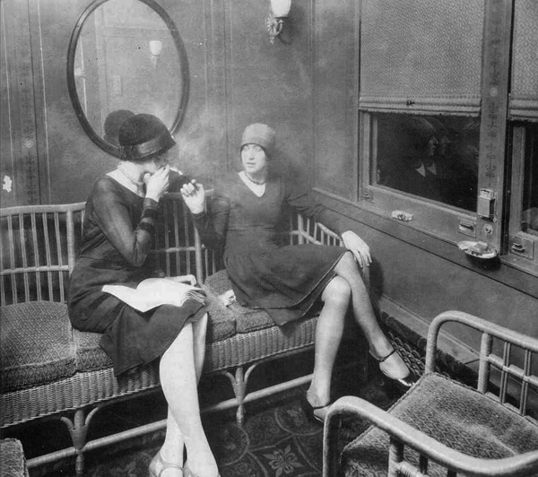 Flapper women smoking in a train car